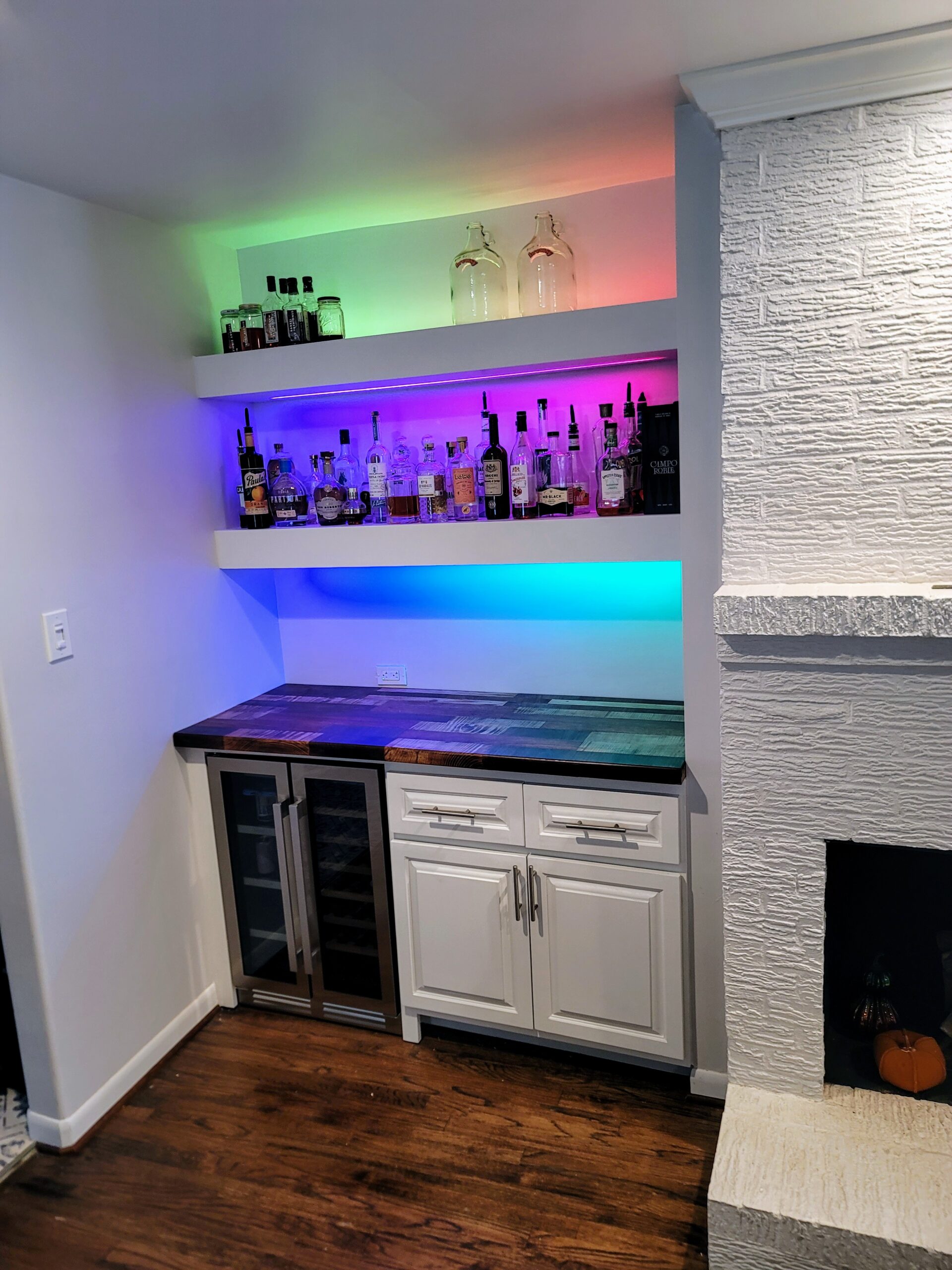 a bar with liquor bottles and a refrigerator